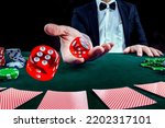Small photo of Gambling concept. Close up of Poker Player male hand throwing dice at casino, gambling club. Đˇasino chips or Casino tokens, poker cards, gambling man lucky guy spending time in games of chance.