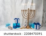 Small photo of Jewish Hanukkah Menorah 9 Branch Candlestick, dreidel, gift boxes. Holiday Candle Holder, dreidl. Nine-arm candlestick. Traditional Hebrew Festival of Lights candelabra. Background with copy space.
