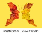Small photo of Psychology and optical illusion abstract concept four faces butterfly image. Flat lay arrangement of different shapes and color of maple leaves against yellow background.