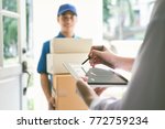 delivery, mail, people and shipping concept.Young woman sign in digital mobile phone after receiving parcel from courier at home.