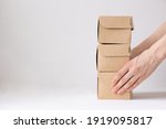 women's hands hold cardboard boxes, natural color, eco-friendly and biodegradable products, boxes for the delivery of food and gifts, confectionery and food