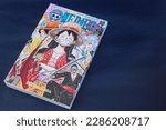 Small photo of Banjar, Indonesia - April 7, 2023: Close up Japanese Manga One Piece Chapter 100. Comic book published in Weekly Shonen Jump Magazine. Isolated in dark blue Background.