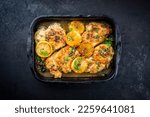 Small photo of Traditional Italian deep-fried chicken piccata with capper and lemon slices offered as top view in a rustic old roasting pan with copy space