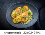 Small photo of Modern style traditional Italian deep-fried chicken piccata with capper and pasta offered as top view in a design plate with copy space