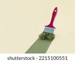 2023. Creative abstract Xmas greeting card with dark red paintbrush with Christmas tree twigs painting green trace. Pastel beige background with copy space. Minimal aesthetic decorative concept.