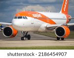 Small photo of Manchester Airport, United Kingdom - 30 June, 2022: Easyjet Airbus A320 NEO (G-UZHR) entering runway 23L for take off to Geneva, Switzerland.