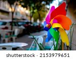Small photo of Colorful pinwheel. Pinwheel or windmill in street decorative object of a cafe. Conceptual cafes or restaurants background photo. Selective focus.