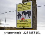 Small photo of Znojmo, Czechia - January 7, 2023: Warning sign: dangerous animal - horse bites can inflict serious injury. Warning sign on horse pasture. Czech and English languages.