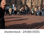 Small photo of Gubbio Umbria, Italy-May 15 2011; People gather in European town square as sun lowers and shadows lengthen in late afternoon.