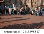 Small photo of Gubbio Umbria, Italy-May 15 2011; People gather in European town square as sun lowers and shadows lengthen in late afternoon.