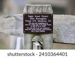 Small photo of Doylestown, PA, USA, 10.23.22 - A sign attached to a wooden fence post giving credit to the Eagle Scounts.