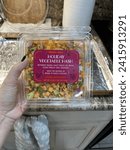 Small photo of Islip Terrace, NY, USA, 10.29.23 - A woman holding a container of Trader Joe's Holiday Vegetable Hash.