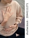 Small photo of Close-up of a woman's hands on her chest while doing breathing exercises. Caucasian woman sitting in a lotus position, practicing pranayama