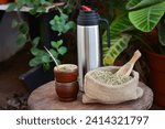 Small photo of Argentine mate plus steel kettle and bag with yerba mate on a rustic table. Sharing a mate in the garden.