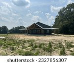 Small photo of Post frame construction pole barn garage with living space, concrete floor, metal walls and roofing, two lean-to’s and front porch