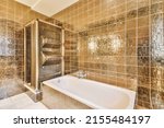 Small photo of Shower faucets attached to tiled wall near bathub and glass partition and ornamental curtail in washroom at home