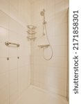 Small photo of Shower faucets attached to tiled wall near glass partition and ornamental curtail in washroom at home