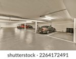 Small photo of an empty parking with cars parked in the garages and two people standing on either side of each other vehicles
