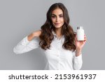 Woman with bottle pills. Happy young African American woman holding bottle of dietary supplements or vitamins in her hands. Healthy hair care concept.