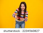 Amazed girl 12, 13, 14 years old with smart phone. Hipster teen girl types text message on cellphone, enjoys mobile app. Kid hold smartphone texting in online social media. Excited teen girl.
