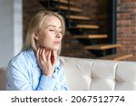 Small photo of Tonsillitis and angina concept. Sick woman with closed eyes touching her sore throat. Unhealthy female with painful feelings in neck feels discomfort, hard to swallow, irritation or loss of voice