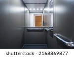 Small photo of Stainless steel elevator cabin interior with mirror. Modern passenger lift with convenient control panel in building. Transportation concept. Accessible environment for disabled people