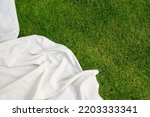 Small photo of top view of picnic blanket on ground, advertising concepts, copy space. linen tablecloth or white textile plaid on green lawn in garden outdoor at summer day, flat lay