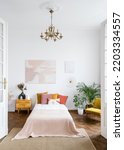 Small photo of The style of the 60s concept. Bright vintage bedroom in apartment with retro interior design. Houseplants in room with authentic chandelier on a high ceiling over tidy bed, side table, armchair