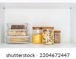 food containers with plastic lid different size at kitchen cupboard, storage of pasta, grains, chickpeas and oats in glassware kitchenware