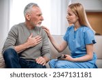 Small photo of General practitioner and elderly patient sitting on sofa and talking about heartache Supportive doctor listening complaints about heart and chest pain. Home visit or private medical centre appointment