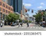 Small photo of New York, NY USA - August 22, 2023 : People crossing 125th Street at the intersection of Frederick Douglass Boulevard with the Apollo Theater in the background in Harlem, NYC
