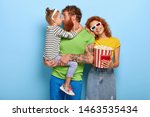 Small photo of Cinema is popular means of mass media. Young family enjoy favourite pastime, watch interesting movie, parents upbring child with educational film, eat popcorn, like big screen and great visual effects