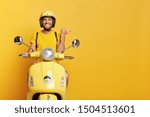 Small photo of People, transport and advertisement concept. Cheerful young European male motorcyclist points thumb away, dressed casually, poses on own motorbike, glad to show copy space for your information