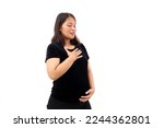 Small photo of Asian pregnant woman standing while feeling breathless. Isolated on white background