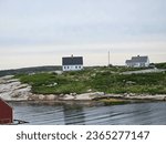 Small photo of Peggy's Cove, NS, CAN, August 15, 2023 - A view of the houses on a hill along the water at Peggy's Cove, Nova Scotia.