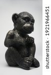 Small photo of Sitting black monkey bibelot on the white background, Thinking monkey
