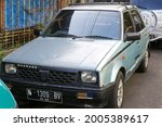 Small photo of Malang, Indonesia -2 july 2021 : a car with the Daihatsu Charade brand with a carriage on the roof close up photographed during the day from the front and side