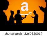 Small photo of USA, WASHINGTON, JANUARY 30, 2023: Amazon. Web Development Dreams Come True: Silhouetted Developers in Discussion with Company Logo