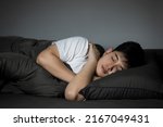 Small photo of Side view of Asian man sleeping in his bed with a bright expression on his face at night. concept of health care with at least eight hours of bed rest.