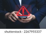 Small photo of Businessman using smartphone with warning triangle showing a system error. Concepts of system maintenance, security, anti-virus, and anti-hacking access to critical data.