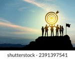 Small photo of Goal setting towards planning for the future. Silhouettes of group businessmen holding target boards with flags planted on a mountain. Concept of a clear planning process and teamwork.