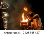 Small photo of Varanasi or Benarras, Uttar Pradesh, India - 18 March 2019: Ganga aarti ceremony rituals performed by Indian Hindu priests on the banks of river ganges at Dashashwamedh Ghat(ghats) on an evening.