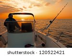 Fishing boat and fisherman in ocean at dawn