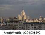 Small photo of Moscow, Russia - October 14, 2022. Stalin's skyscraper with white stone walls against the background of a gray gloomy sky among the poorer houses and roofs. Editorial use only.