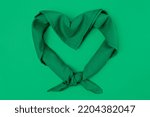 Green scarf on a green background in the shape of a heart for September 28, legal and safe abortion. High quality photo