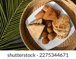 Small photo of Authentic Sri Lankan different street food, short eats. Vegetable roti, coconut roti, cutlets, mutton rolls on white plate. View from above. Copy space.