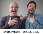 Two men and son laughing on their friend joke having a good mood. Positive facial emotion.