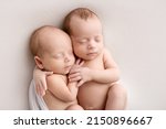 Small photo of Tiny newborn twins boys in white cocoons on a white background. A newborn twin sleeps next to his brother. Newborn two twins boys hugging each other.Professional studio photography