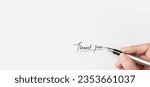 Small photo of A hand of businesswoman writing on paper in the office. Hand writing thank you on piece of paper.