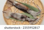 Small photo of Japanese flying squid on a bamboo basket.Raw uncooked squid.